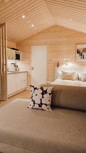 a bedroom with a large bed and a kitchen at Kataja Chalet with sauna and jacuzzi in Rovaniemi