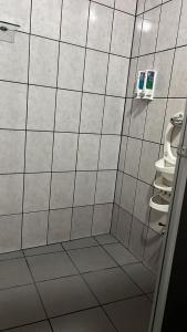 福尔图纳Hotel FAS的带淋浴的浴室和白色瓷砖墙壁