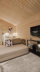 a bedroom with a bed and a flat screen tv at Kataja Chalet with sauna and jacuzzi in Rovaniemi