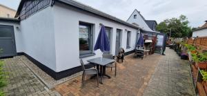Un patio con una mesa y sillas al lado de un edificio. en Ankes Pension "Koje 7", en Rostock