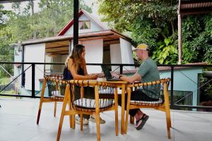 a man and woman sitting at a table with a laptop at ONDA Boquete in Boquete