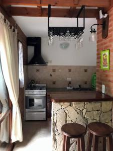 a kitchen with a stove and a counter with stools at okin 11 flores in Costa del Este +12 photos
