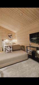 a bedroom with a bed and a flat screen tv at Kataja Chalet with sauna and jacuzzi in Rovaniemi +9 photos