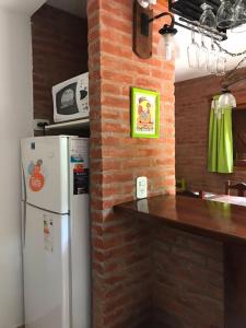 a kitchen with a white refrigerator and a brick wall at okin 11 flores in Costa del Este