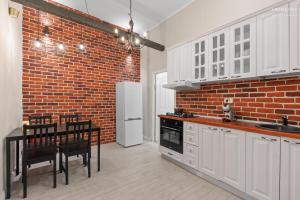 una cucina con mobili bianchi e un muro di mattoni di The Brick Loft 1BR Calea Victoriei a Bucarest Altre 13 foto