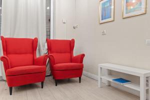 due sedie rosse sedute accanto a un tavolo bianco di The Brick Loft 1BR Calea Victoriei a Bucarest