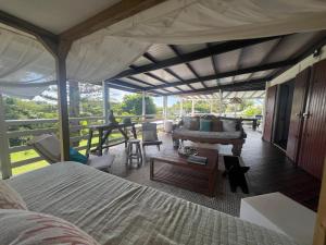 a bedroom with a bed and a living room at La Villa Mandala à 500 m de la plage in Belle-Allée