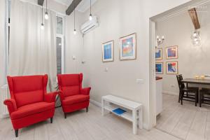 un soggiorno con due sedie rosse e un tavolo di The Brick Loft 1BR Calea Victoriei a Bucarest