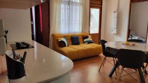 a kitchen and living room with a yellow couch at Osvalley Résidence in Basse-Terre +1 photo