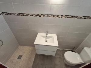 a bathroom with a white sink and a toilet at Osvalley Résidence in Basse-Terre