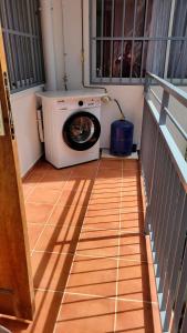 a washing machine sitting on the floor of a balcony at Osvalley Résidence in Basse-Terre