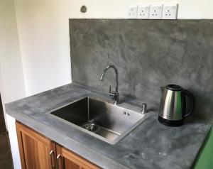 a kitchen counter with a stainless steel sink at Yohan Eco Lodge Udawalawe in Udawalawe