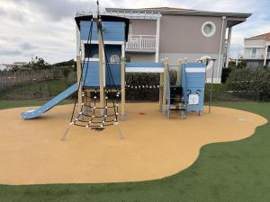een speeltuin voor een huis met een glijbaan bij Les Sables-d'Olonne - Vue Mer, Terrasse, Wifi Fibre & Piscine, à 2 pas de l'Océan - E101 in Les Sables-dʼOlonne