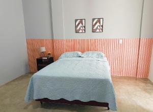 ein Schlafzimmer mit einem Bett und einer rot gestreiften Wand in der Unterkunft Asas da Maré Pousada in Bragança