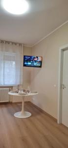 a room with a table and a tv on the wall at Appartamento Padova Chiesanuova in Padova