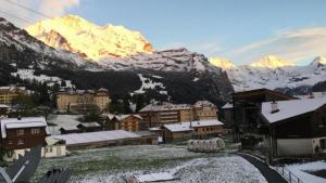 a town with a snow covered mountain in the background at Katharina Von Allmen in Wengen