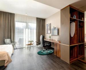 a bedroom with a bed and a desk and a chair at Woda i góry - studio z widokiem na góry i zalew in Sosnówka