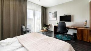 a bedroom with a bed and a desk with a computer at Woda i góry - studio z widokiem na góry i zalew in Sosnówka