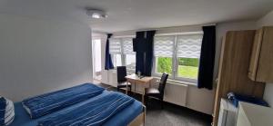 Un dormitorio con una cama y un escritorio y una ventana. en Ankes Pension "Koje 7", en Rostock