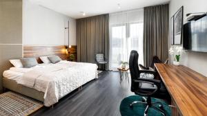 a bedroom with a bed and a desk with a chair at Woda i góry - studio z widokiem na góry i zalew in Sosnówka