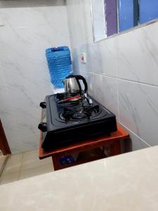 a tea kettle sitting on a stove in a kitchen at Serene63 Studios Kenol,Muranga in Gitura