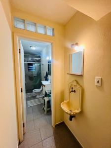 um banheiro com uma pia e um vaso sanitário em Casa no Centro de Águas de Lindóia com Piscina em Águas de Lindóia