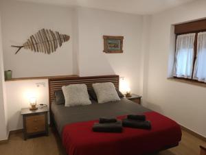 a bedroom with a large bed with a red blanket at Apartamentos ROSAMUNDA SANTANDER in Santander