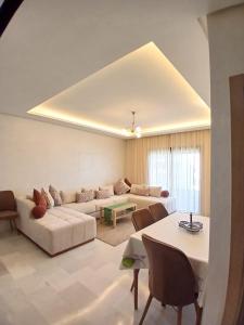 Aïn HarroudaCozy Studio Vue sur Piscine à Ocean Park Zenata City Eco的客厅里有一张沙发和一张桌子。