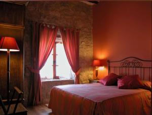 La Casa de las Monjas في Miranda de Arga: غرفة نوم بسرير مع ستائر حمراء ونافذة