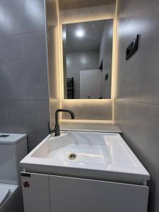 Aghk'ilisacozy and warm apartment的浴室里有洗手池和镜子 更多9张照片