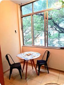 a table and two chairs in a room with a window at Quarto com Anfitriã em Copa in Rio de Janeiro +18 photos