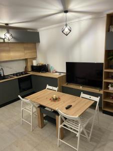 a kitchen with a wooden table and chairs in it at Apartament Bonton Predeal in Predeal