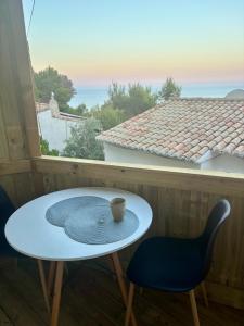 a table and chairs on a balcony with a coffee cup at Casa Halcón in Jávea