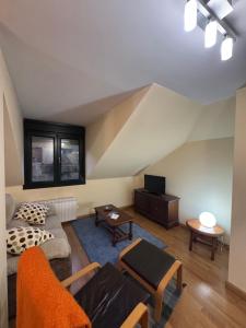 a living room with a couch and a table at Ático luminoso en Felechosa in Felechosa