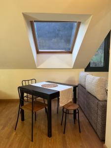 a table and chairs in a room with a window at Ático luminoso en Felechosa in Felechosa +7 photos