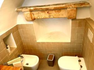 a bathroom with a white toilet and a sink at Trulli Donna Grazia in Martina Franca +12 photos