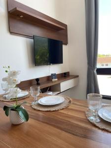 a dining room table with plates and a television at Apartamento Texas in Pomerode