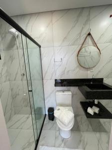a bathroom with a toilet and a glass shower at Apartamento Texas in Pomerode