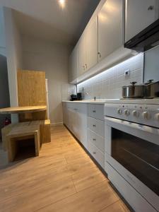 a kitchen with white cabinets and a stove and a table at Karpenisi Nest in Karpenisi