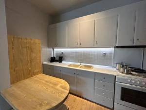 a kitchen with white cabinets and a sink and a table at Karpenisi Nest in Karpenisi