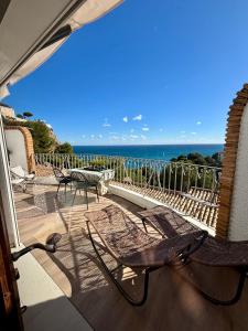 a patio with chairs and a table and the ocean at Casa Halcón in Jávea
