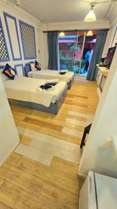 two beds in a room with wooden floors at kodus hotel boutique in Pattaya South