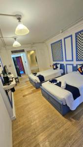 a bedroom with two beds and a desk with a television at kodus hotel boutique in Pattaya South