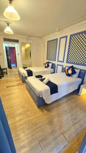 three beds in a bedroom with blue walls and wooden floors at kodus hotel boutique in Pattaya South +24 photos