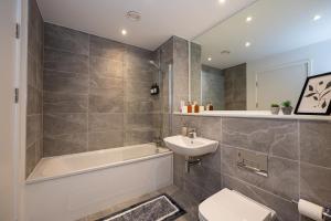 ein Badezimmer mit Badewanne, Waschbecken und Toilette in der Unterkunft Pet friendly 2BR near Piccadilly in Manchester