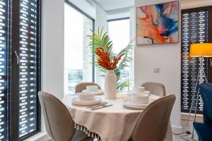 einem Esstisch mit Stühlen und einer Vase darauf in der Unterkunft Pet friendly 2BR near Piccadilly in Manchester + 12 Fotos