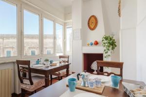 a dining room with a table and some windows at BED&BREAD Piazza 'Nzegna in Carovigno