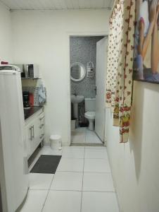 een witte badkamer met een toilet en een wastafel bij Studio na praia in Praia Grande