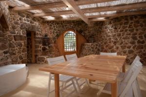 une salle à manger avec une table en bois et des chaises blanches dans l'établissement Villa Petra Viva, à Ugento