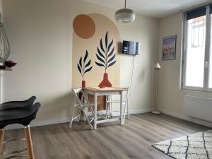 a room with a table and chairs and a wall at Studio 4 Emplacement Idéal entre Château et Centre in Fontainebleau